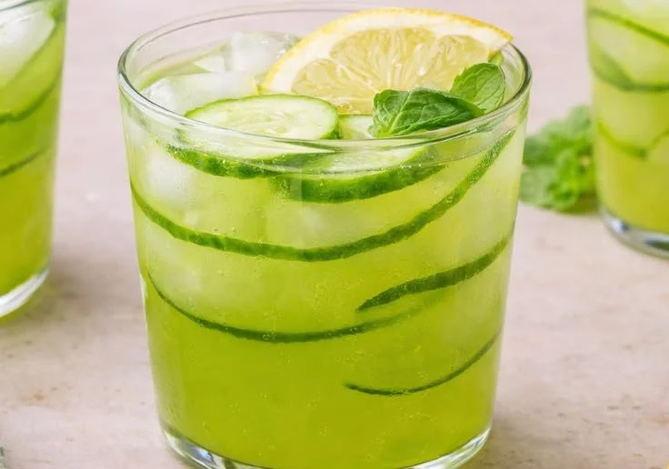 Refreshing glass of Cucumber Mint Lemonade topped with mint leaves.