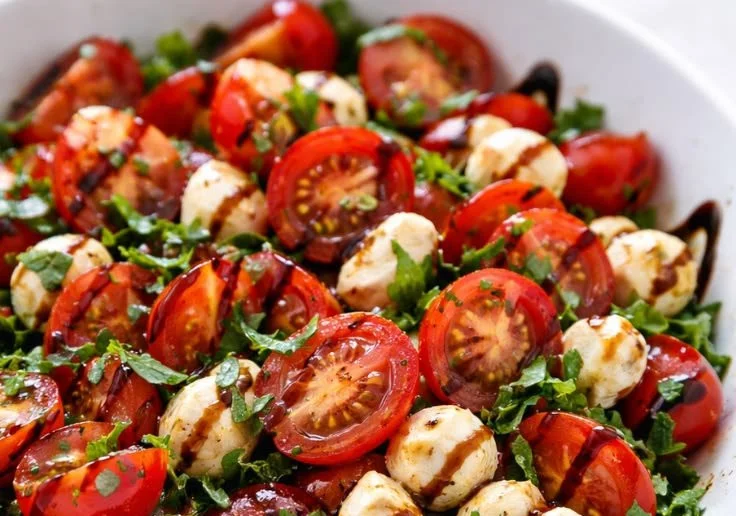 Delicious fresh Caprese salad bowl with mozzarella, tomatoes, and basil