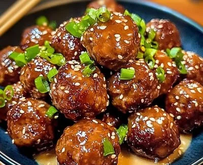 Delicious Korean BBQ meatballs served with dipping sauce and garnishes.