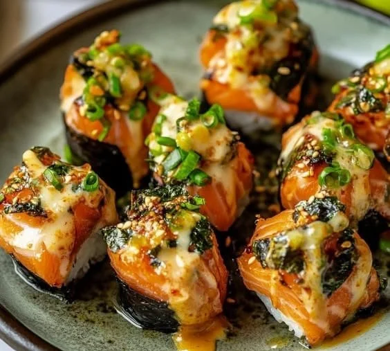 Oven-baked salmon sushi bites served on a plate with garnishes.