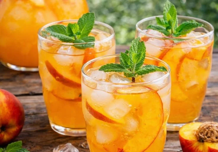 Refreshing glass of homemade peach lemonade with fresh peaches