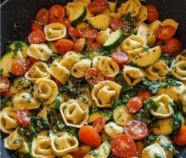 Tortellini pasta tossed with fresh summer vegetables and herbs