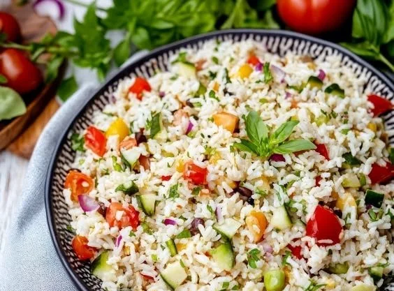 Colorful vibrant rice salad with fresh vegetables and herbs