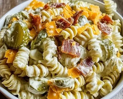 Delicious dill pickle pasta salad served in a bowl with fresh herbs.