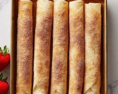 Delicious cheesecake taquitos served on a plate with dipping sauce