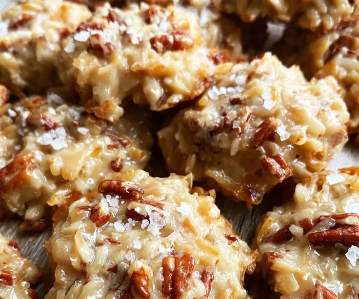 Coconut Praline Cookies stacked on a plate, drizzled with chocolate.