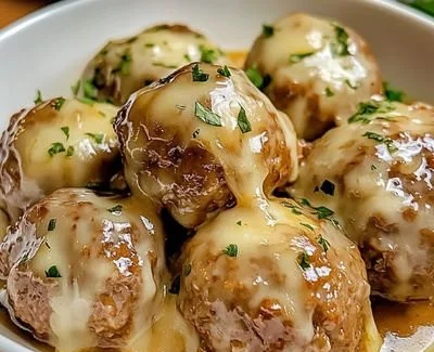 Delicious Crock Pot French Onion Meatballs simmering with onions and savory broth.