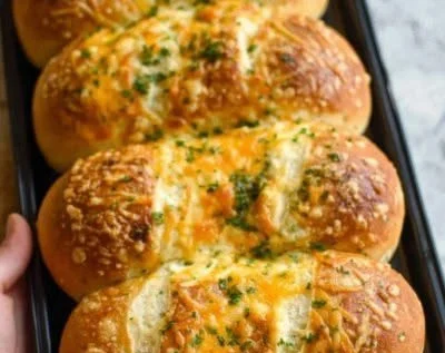 Freshly baked herbed Italian bread rolls on a wooden table