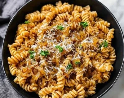 Delicious One-Pot French Onion Pasta garnished with cheese and herbs.