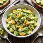 Delicious Avocado Egg Salad served in a bowl with fresh herbs.